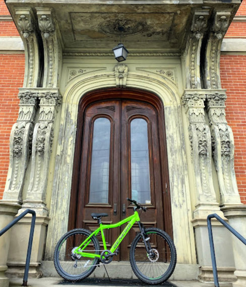 A green bicycle sits on the steps at IKRON's Graveson building